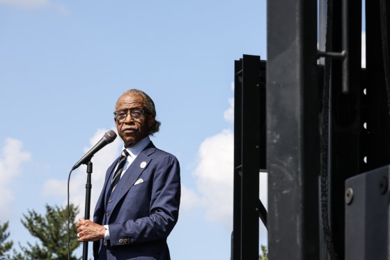 Al Sharpton standing at a microphone outdoors.