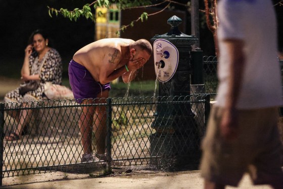 A man cools down at a public drinking fountain along the Canal Saint-Martin as France experiences a heatwave, in Paris on June 25, 2026.
