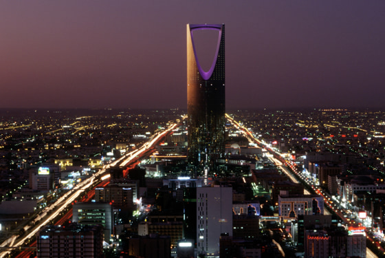 The Burj al-Mamlaka rises above the skyline of Riyadh at dusk.