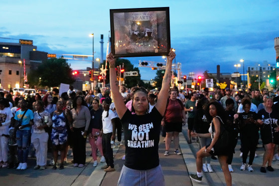 A protester holds a photo of Corey Durell Ruiz as they march in Madison, Wis.