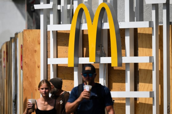 The McDonalds logo is displayed as people walk in the street.