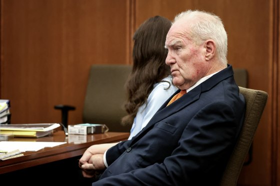 Defense attorney Kevin Reddington holds the hand of Lindsay Clancy