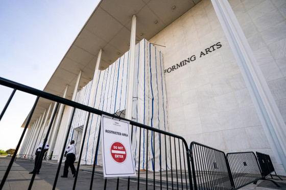The John F. Kennedy Center for the Performing Arts exterior, tarp covers the front, and a gate can be seen blocking off entry, a sign is on the gate that reads "restricted area, and a Do Not Enter logo"