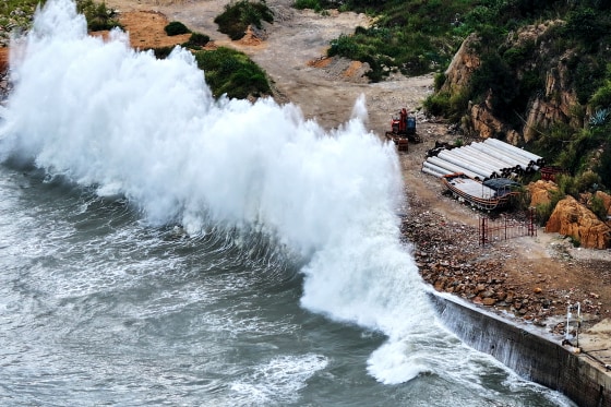 A huge wave crashes onto shore.
