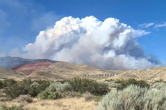 A cloud of smoke can be seen over a mountainscape