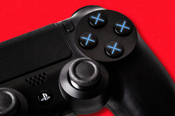 A close up of a black PlayStation controller, showing the four operational buttons with all blue X's instead of the regular four different shapes, against a red background