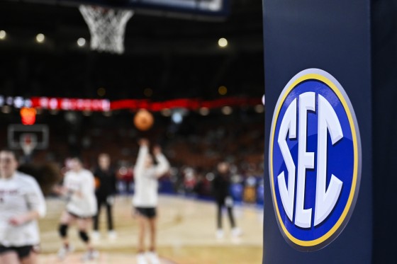 The SEC logo is seen while people play on the court.