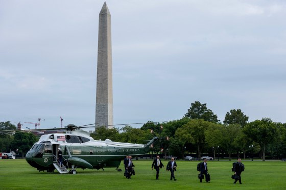United States Secret Service agents walk away from a helicopter.