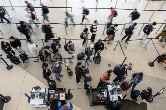 A blur of travelers in an airport seen from above.