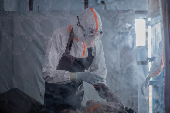 A doctor in a protective gear provides care to a patient.
