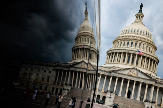 The exterior of the U.S. capitol building is reflected on a surface seen on the left
