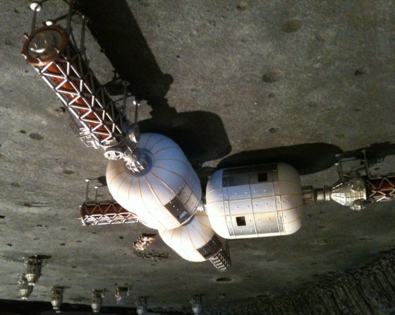 A scale model shows Bigelow Aerospace's proposed lunar colony, prefabricated using inflatable modules, with lunar landers in the background.