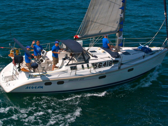 A member of the yacht Aegean waves at the camera at the start of the Newport to Ensenada Yacht Race off the waters of Newport Beach, California on April 27.