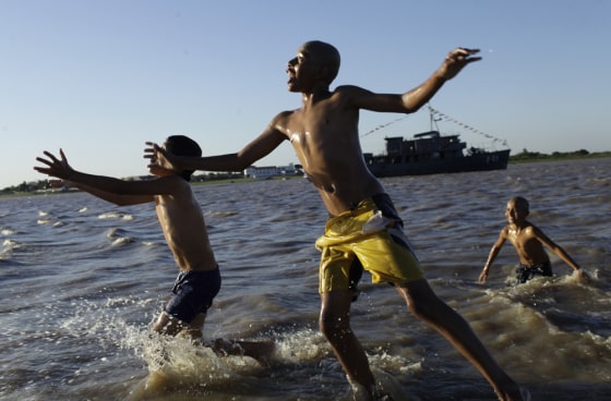 Children play in the water in Asuncion Bay, Paraguay on Oct. 14. A newly released poll of nearly 150,000 people around the world says seven of the world's 10 countries with the most upbeat attitudes are in Latin America. Panama and Paraguay came out on top of the list.