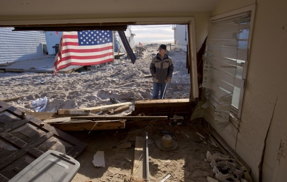 Bob Hauck looks over what is left of his home at 210 Oceanside in the Breezy Point neighborhood of Queens, NY.