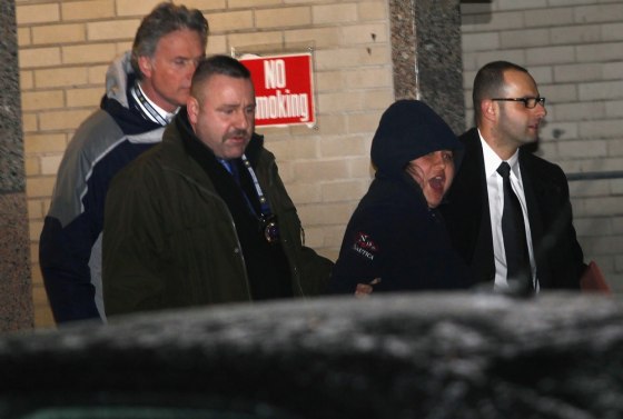 New York City police officers escort 31-year-old Erika Menendez to a waiting car as she screams in Queens, New York City, on Saturday.