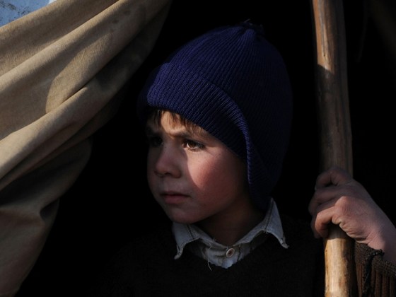 An internally displaced Afghan boy looks out from a tent where he lives at a camp in Dihdadi district in the outskirts of Mazar-i-Sharif in Balkh province on January 8, 2012. Mazar-i-Sharif is the capital of Balkh province with existence of multi-ethnic groups such as Uzbeks, Turkmen, Tajiks and Hazaras. In literary Mazar-i-Sharif means â€˜Respected Shrineâ€™ but the city is known by tourists as city of the blue mosque which is located in the center of the city known as the Shrine of Hazrat Ali. AFP PHOTO/Qais Usyan (Photo credit should read QAIS USYAN/AFP/Getty Images)