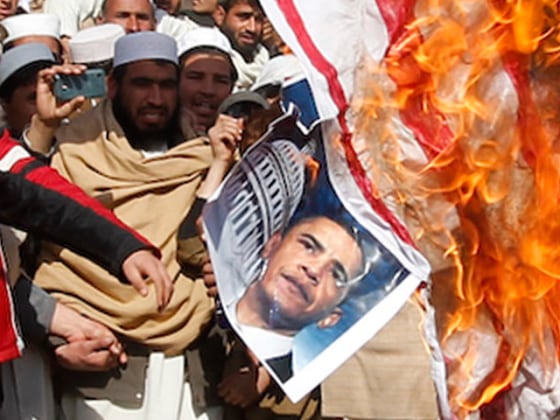 Afghan protesters burn a U.S. flag during a protest in Jalalabad province February 24, 2012. Twelve people were killed on Friday in the bloodiest day yet in protests that have raged across Afghanistan over the desecration of copies of the Muslim holy book at a NATO military base with riot police and soldiers on high alert braced for more violence. REUTERS/Parwiz (AFGHANISTAN - Tags: CIVIL UNREST RELIGION TPX IMAGES OF THE DAY)