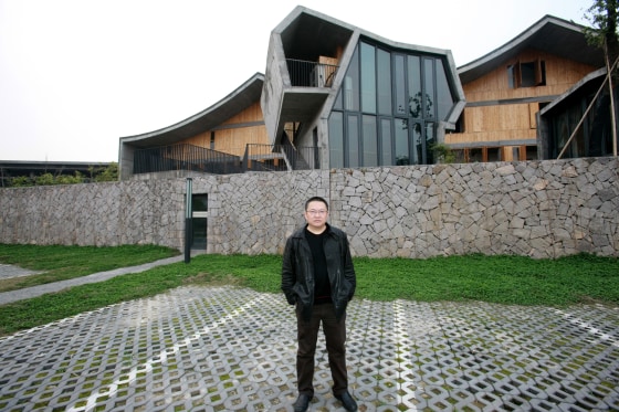 --FILE--Chinese architect Wang Shu, owner of the Amateur Architecture Studio, poses in front of an architecture he designed at the Xiangshan campus of China Academy of Art in Hangzhou city, east Chinas Zhejiang province, 18 March 2009. Chinese architect Wang Shu, whose buildings in a rapidly developing China honor the past with salvaged materials even as they experiment with modern forms, has been awarded the 2012 Pritzker Architecture Prize. Mr. Wang is the first Chinese citizen to win the prize (I.M. Pei, an American, was the first Chinese-born architect to win, in 1983) and the fourth-youngest. The selection of Mr. Wang, 48, is an acknowledgment of the role that China will play in the development of architectural ideals, said Thomas J. Pritzker, chairman of the Hyatt Foundation, which sponsors the prize and announced the winner on Monday (27 February 2012).