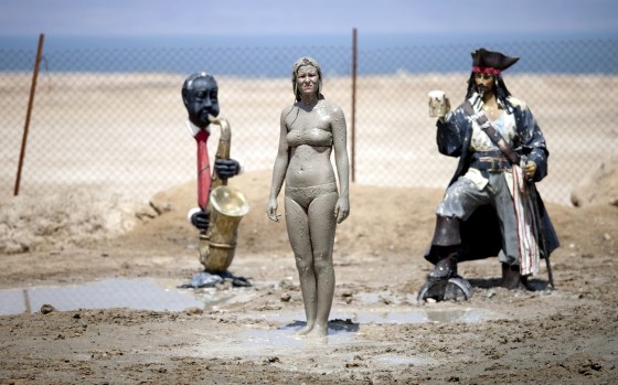 A tourist smeared with mud from the Dead Sea stands in a coastal resort near Ein Gedi, Israel on July 25.