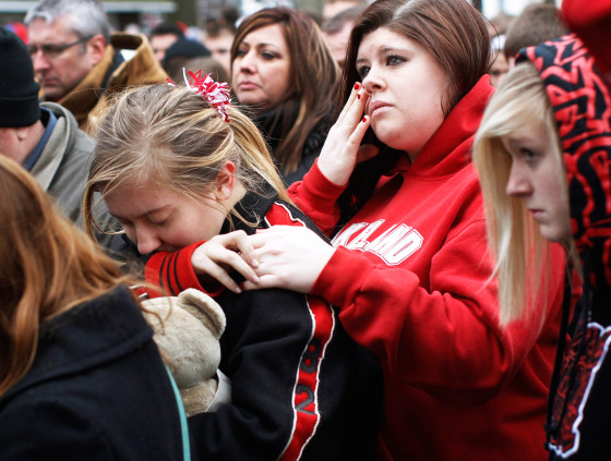 Students and parents gather outside a memorial remembering the victims of the Chardon High school shootings before returning to school for the first time since the shootings in Chardon, Ohio March 1, 2012. Three students were killed and two others wounded by suspect TJ Lane in Monday's shooting rampage at the Ohio high school. REUTERS/Shannon Stapleton (UNITED STATES - Tags: CIVIL UNREST CRIME LAW EDUCATION)