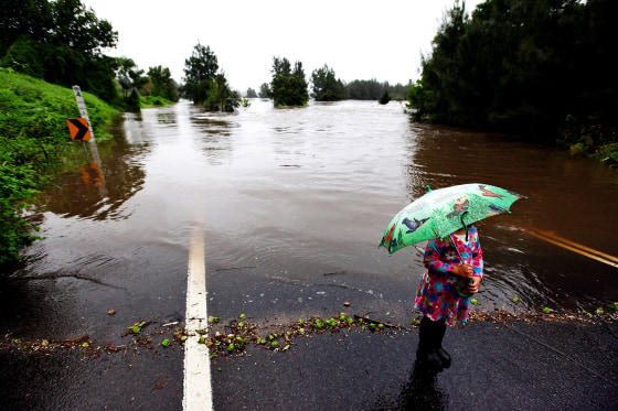 RICHMOND, AUSTRALIA - MARCH 03: Locals look on as the waters of the Hawkesbury River continue to rise completely covering the Yarramundi Bridge on March 3, 2012 in Richmond, Australia. Over 1000 people have been evacuated as record rainfall continues across at least three quarters of the state of NSW. Sydney and surrounding areas experienced one of the wettest and coolest summers in many years, which looks set to continue into March. (Photo by Marianna Massey/Getty Images) *** BESTPIX ***