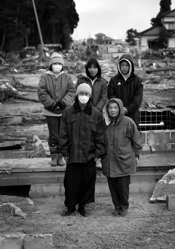 Akiyo Hirayama, 70, front right, and her grandson Jun, 19, front left, stand with their family in front of the remains of their house in Sendai, Miyagi, Japan on April 4, 2011 after a massive earthquake and tsunami swept away the house on March 11. Akiyo spent a night on the roof of a car as Jun hung onto a tire before they were rescued. Photo by Kuni Takahashi