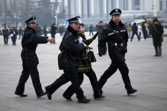 A Chinese police officer drags away a protesting woman after a flag raising ceremony on Tiananmen Square across from where the National People's Congress is held, in Beijing, China, Monday, March 5, 2012. The cause of the incident was not known but authorities have tighten security of the area around the Great Hall of the People where the annual legislature meetings are held this week. (AP Photo/Andy Wong)