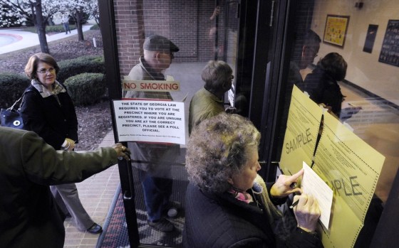 Mary Lou Andrews stops to fill out a voter certification card as others go in to Medlock Bridge Elementary School to cast their ballots in the Republican primary, on Super Tuesday, March 6, 2012, in Johns Creek, Ga. (AP Photo/John Amis)