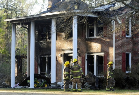 Firefighters look at the front of a heavily damaged two- story home where a Special Forces soldier died trying to rescue his 2 small children during a house fire early Tuesday, March 6, 2012 in Hope Mills, N.C. Mother Louise Cantrell, 37, was injured in the blaze that started around 2:00 am. Edward Duane Cantrell, 36, and his daughters, 6-year old Isabella Cantrell and 4-year old Natalia Cantrell all perished in the fire. (AP Photo/The Fayetteville Observer, Marcus Castro) MANDATORY CREDIT