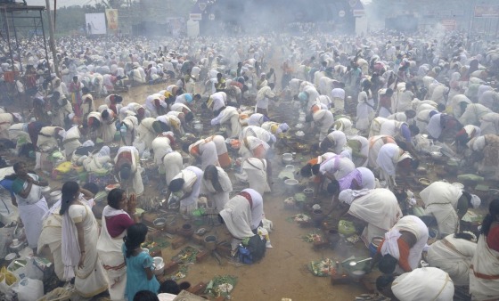 Hindu devotees pray and prepare rice porridge in the streets surrounding the Attukal Bhagavathy Temple in Thiruvananthapuram on Wednesday as they take part in the Pongala Festival or Attukal Pongala in the southern state of Kerala. More than 3.5 million women took part in the festival which is attempting entry into the Guiness Book of World Records for the largest gathering of women at a festival in the world.