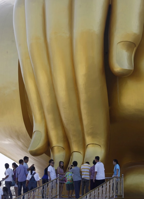 Thais gather near the right hand of the giant Buddha statue during Makha Bucha Day.