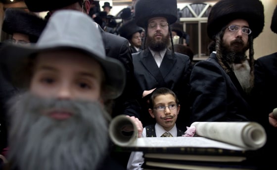 Ultra-Orthodox Jews read the Esther scrolls at a synagogue in the Israeli town of Bnei Brak near Tel Aviv on March 7, 2012 during celebrations of the Purim holiday. The carnival-like Purim holiday is celebrated from the evening of March 7 with parades and costume parties to commemorate the deliverance of the Jewish people from a plot to exterminate them in the ancient Persian empire 2,500 years ago, as recorded in the Biblical Book of Esther. AFP PHOTO/MENAHEM KAHANA (Photo credit should read MENAHEM KAHANA/AFP/Getty Images)