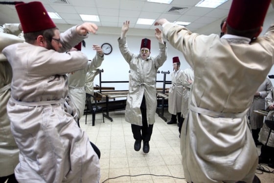 epa03137672 Ultra-Orthodox Jewish men dance and sing during a celebrations for the holiday of Purim at the Matmidim Hasidic dynasty synagogue in Jerusalem, Israel, 08 March 2012. The Jewish holiday of Purim celebrates the Jews' salvation from genocide in ancient Persia, as recounted in the Scroll of Esther. EPA/ABIR SULTAN