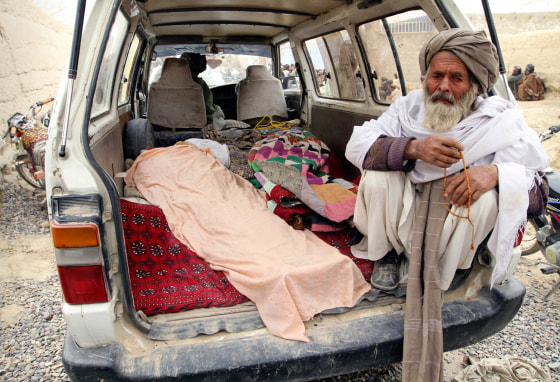 An elderly Afghan man sits next to a covered body, who was allegedly killed by a U.S. service member, in a minibus in Panjwai, Kandahar province south of Kabul, Afghanistan, Sunday, March 11, 2012. A U.S. service member walked out of a base in southern Afghanistan before dawn Sunday and started shooting Afghan civilians, according to villagers and Afghan and NATO officials. Villagers showed an Associated Press photographer 15 bodies, including women and children, and alleged they were killed by the American. (AP Photo/Allauddin Khan)
