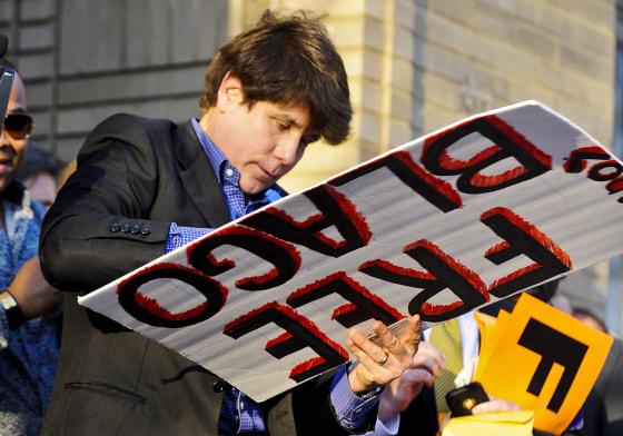 epa03145139 Former Illinois Governor Rod Blagojevich autographs a sign calling for his freedom outside his home on the day before he is to report to prison on his corruption conviction in Chicago, Illinois, USA 14 March 2012. Blagojevich was convicted for attempting to sell the US Senate seat formerly held by President Barack Obama, among other charges. He is scheduled to report to the Federal corrections facility in Littleton, Colorado, USA to begin his 14 year sentence on 15 March. EPA/TANNEN MAURY