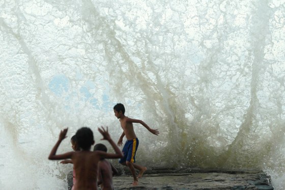 An East Timorese child runs as sea water hits the wall on Dili beach March 15, 2012. REUTERS/Beawiharta (INDONESIA - Tags: SOCIETY)