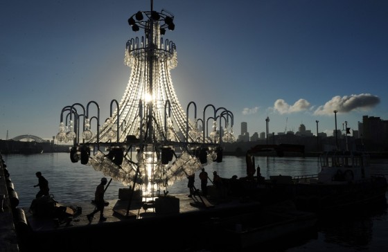 Riggers prepare a 9x9 m high chandelier covered with 10,000 Swarovski crystals prior to it being sailed up Sydney Harbour to take its place on a floating stage at Farm Cove in Sydney, Australia on Friday. he chandelier is part of the set for the La Traviata, an opera to be held outdoors and set against the Sydney Opera House.