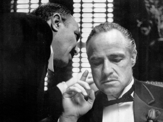 By tradition, the Godfather cannot refuse a request on his daughter's wedding day, and Bonasera, portrayed by Frank Puglia, asks Don Corleone, portrayed by Marlon Brando, at right, for a favor. This is a scene from the 1972 movie
