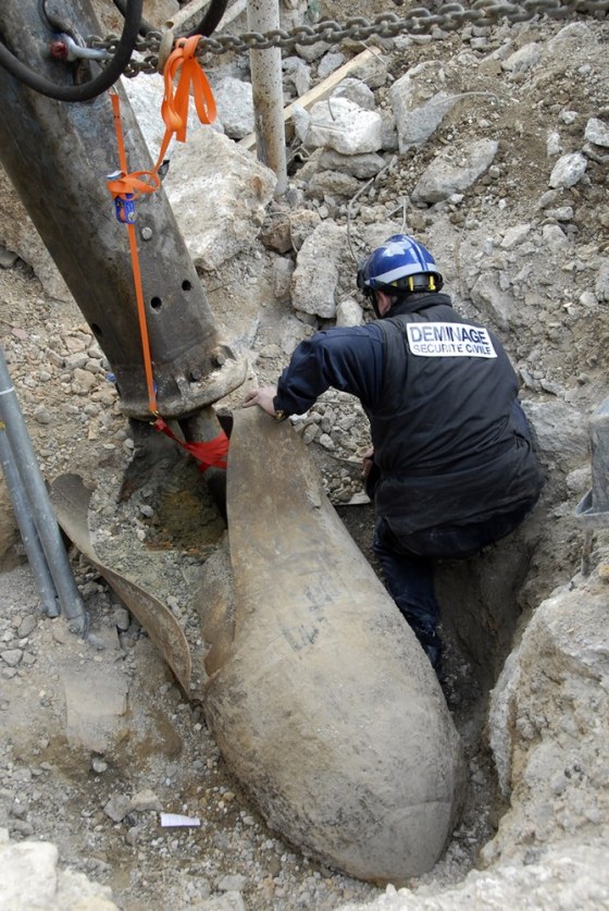 An explosives expert works on the 650-kilo World War II German bomb discovered on a building site of Marseille's harbour, March 18, 2012. Some 1,500 people were evacuated from surrounding districts to allow the operation to go ahead. REUTERS/Bmpm/Handout (FRANCE - Tags: MILITARY) NO SALES. NO ARCHIVES. FOR EDITORIAL USE ONLY. NOT FOR SALE FOR MARKETING OR ADVERTISING CAMPAIGNS. THIS IMAGE HAS BEEN SUPPLIED BY A THIRD PARTY. IT IS DISTRIBUTED, EXACTLY AS RECEIVED BY REUTERS, AS A SERVICE TO CLIENTS. NO COMMERCIAL USE