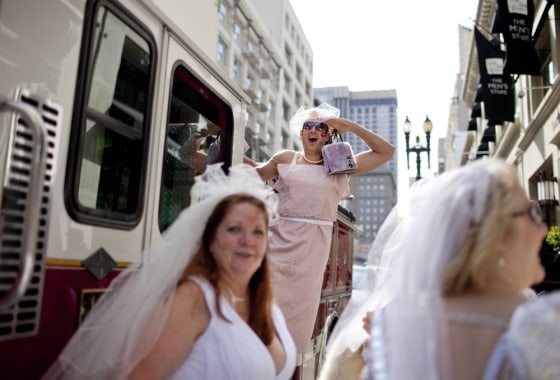 Joe Calavita (C) stands on a fire truck during the March of Brides parade through downtown San Francisco March 18, 2012. People don wedding clothes and stroll through the center of San Francisco during the annual event. REUTERS/Jana Asenbrennerova (UNITED STATES - Tags: SOCIETY TPX IMAGES OF THE DAY)