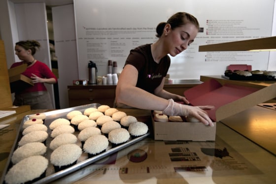 In this photo taken Monday, March 5, 2012, Sprinkles Cupcakes Sara Cebulski, right, arranges a custom box of cupcakes at Sprinkles in Beverly Hills, Calif. A new 24-Hour Cupcake