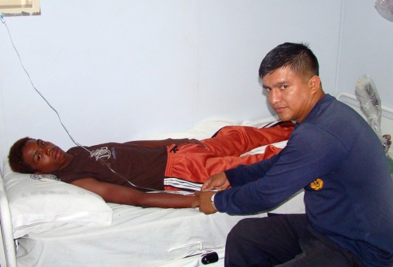 In this photo released by Ecuador's navy, Adrian Vasquez, left, an 18-year-old Panamanian who worked as a maid in a seaside resort hotel, receives medical attention aboard an Ecuadorean navy ship offshore Galapagos Islands, Ecuador, Sunday, March 25, 2012. Vasquez, who took up an offer by two friends to join them on a fishing trip and earn some extra cash, was rescued at sea north of the Galapagos on Friday March 23, 2012 by another fishing boat after he and the two companions, who were found dead, had been missing since Feb. 24. (AP Photo/Ecuador's navy)