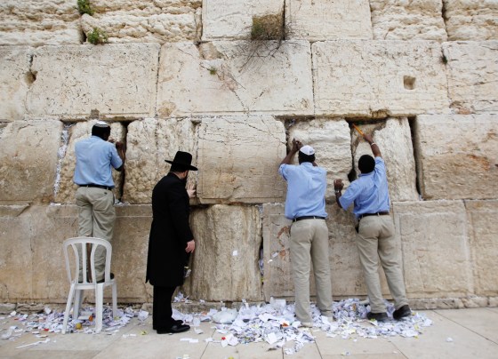 Western Wall Rabbi Shmuel Rabinovitz (2nd L) and workers remove notes from the cracks of the Western Wall, Judaism's holiest prayer site, in Jerusalem's Old City March 28, 2012. Rabbi Rabinovitz headed a team on Wednesday that cleaned out the cracks and made room for more paper notes that Jews believe are notes to God, ahead of the Jewish holiday of Passover which begins on April 6. REUTERS/Ammar Awad (JERUSALEM - Tags: RELIGION)