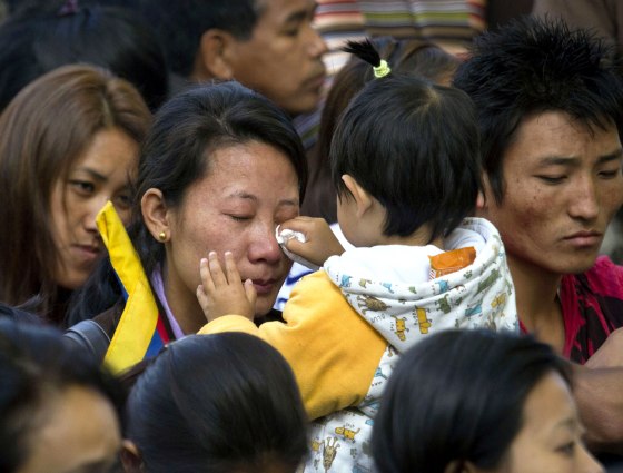 A Tibetan exile child wipes tears off her mother's face during a special ceremony for 27-year-old Jamphel Yeshi who burned himself alive as an act of protest against the visit by China's president in New Delhi.