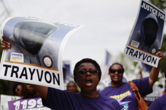 Demonstrators hold signs aloft as they march during an NAACP march and rally to the Sanford Police Department for Trayvon Martin in Sanford, Fla., March 31. Sanford is the town where Trayvon Martin, 17, was shot dead on Feb. 26 after George Zimmerman, 28, a Hispanic neighborhood watch captain, believed the young man walking through the gated community in a hooded sweatshirt looked suspicious.