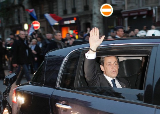 Outgoing French President Nicolas Sarkozy waves from his car as he leaves after addressing supporters at his Union for a Popular Movement (UMP) party headquarters after the the preliminary results of the second round of the presidential elections were announced in Paris Sunday May 6, 2012. Socialist Francois Hollande defeated Sarkozy on Sunday to become France's next president, Sarkozy conceded defeat minutes after the polls closed.