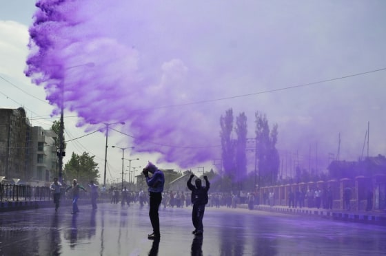 Kashmiri government employees are sprayed with purple colored water by Indian police to disperse a protest in Srinagar on May 9.