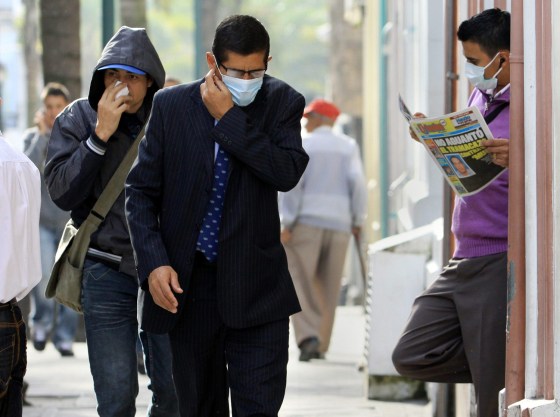 People cover their faces to keep them from breathing ashes created by Ruiz volcano's eruption in Manizales, Colombia, on May 29. Colombian authorities elevated the alert to orange, after an unusual increase in the volcano activity.