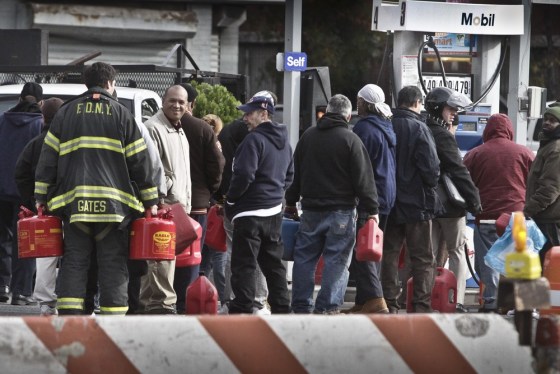 A fireman joins a gas line to get fuel for firehouse generators on Manhattan's lower east side. Lines were shorter Tuesday, but many stations remained...